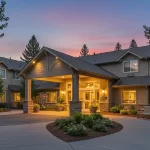 A peaceful and inviting exterior view of The Bridge at Valley View, featuring well-maintained grounds, shaded seating areas, and a welcoming entrance. Title: The Bridge at Valley View Assisted Living