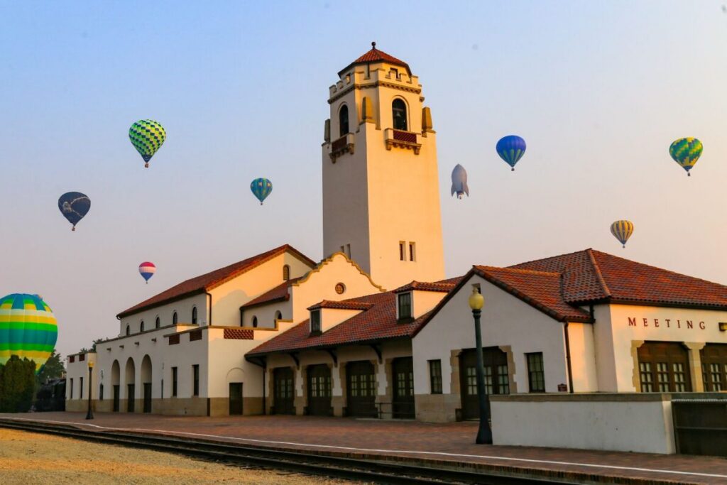 Colorful hot air balloons float above a historic landmark on a clear morning, showcasing the scenic charm and vibrant culture that make Boise, Idaho one of the top destinations for senior communities and retirement.